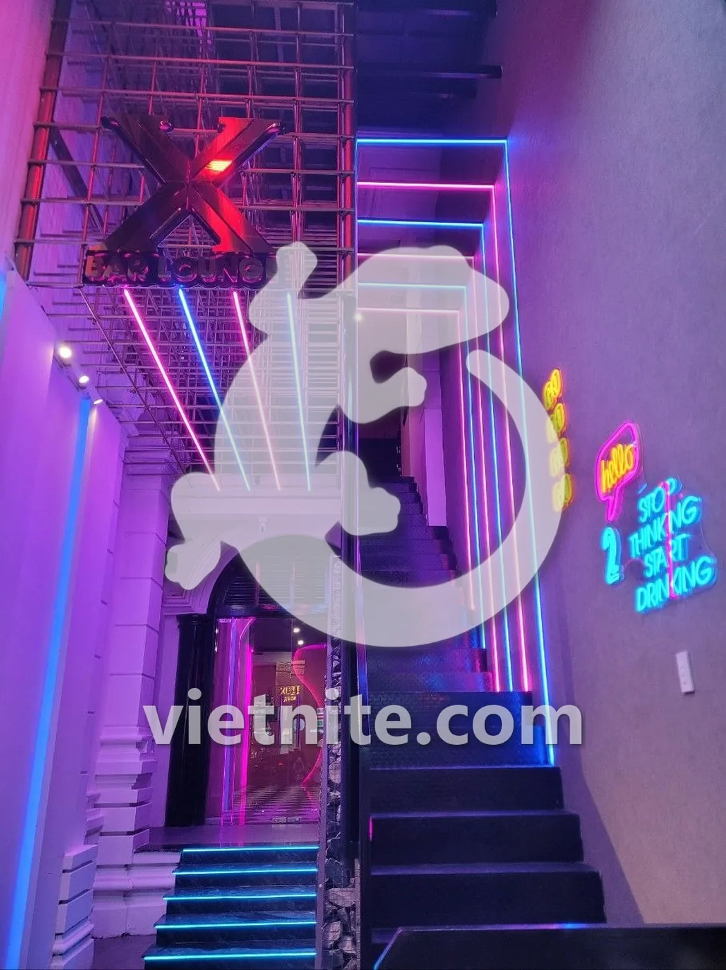 나트랑 X바 라운지 입구 — 네온 조명이 켜진 위층 계단과 X BAR LOUNGE 간판